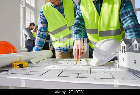 Construction engineers, architects or builders by office table with blueprint plans Stock Photo
