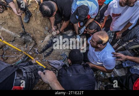 Rafah, Palestinian Territories. 13th Oct, 2023. Palestinians search for survivors following an Israeli bombing in the Rafah refugee camp in the southern Gaza Strip as fighting between Israeli troops and Islamist Hamas terrorists continues. Credit: Abed Rahim Khatib/dpa - ATTENTION: graphic content/dpa/Alamy Live News Stock Photo