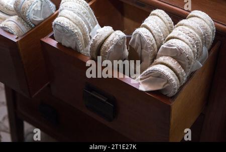 Wooden drawer full of white espadrille shoes. Disposable shoes for wedding guests Stock Photo