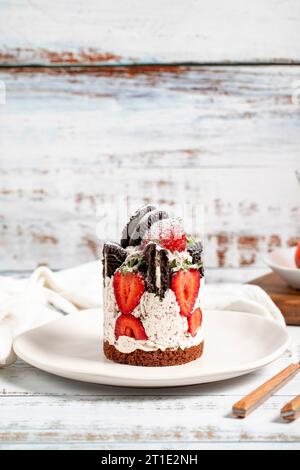 Strawberry and cookie cake. Fresh cake with cream and strawberries on a plate Stock Photo