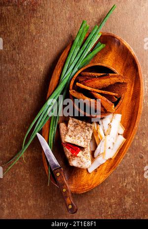 Pork fatback with spices, rye bread and green onion on wooden table Stock Photo