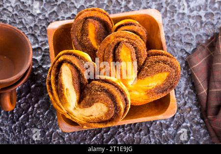 Freshly baked cinnamon rolls in wooden bowl Stock Photo