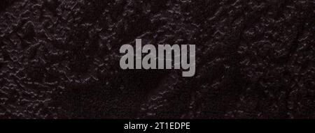Dark brown background from a soft upholstery textile material, closeup. Black fabric with natural texture. Cloth backdrop. Stock Photo