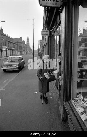 Two elderly ladies stood talking in a tobacconist newsagents shop doorway during the slum clearance and demolition of St Ann's, Nottingham. 1969-1972. Stock Photo