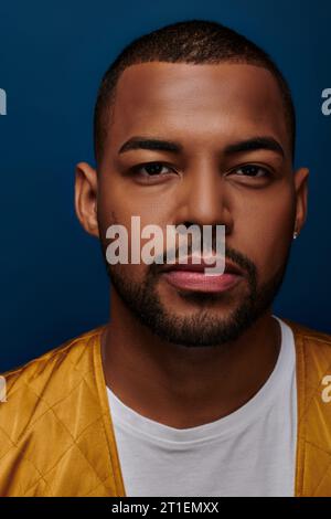 portrait of young bearded man with diamond earring looking straight at camera, fashion concept Stock Photo