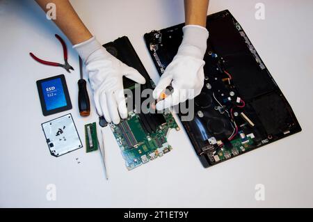 Top view. Technician repairing notebook computer, repairing motherboard and circuit. Stock Photo