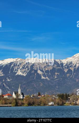 St. Martina Parish Church (Župnijska Cerkev sv. Martina) photographed from across Lake Bled. In the background, the mountain Stol (Hochstuhl). Stock Photo