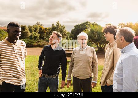 Happy multigenerational group of men with different ethnicities having fun in a public park - People diversity concept Stock Photo