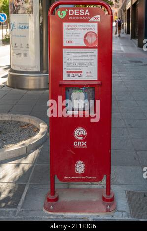 Granada, Spain; August-23, 2023: Red booth with an automatic defibrillator on a street in Granada, Spain Stock Photo