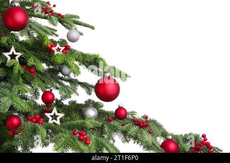 Christmas tree branches on white background. Closeup of decorated fir branches with red and silver baubles, isolated on white Stock Photo