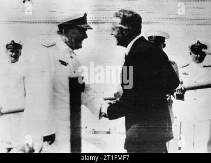 IWM caption : Rear Admiral Sir Henry Harwood is greeted by the British Minister to Uruguay, Mr E Millington-Drake after his arrival at Montevideo. Admiral Harwood arrived in the cruiser HMS AJAX after the Battle of the River Plate and the scuttling of the ADMIRAL GRAF SPEE. Note that this photograph has been reproduced in mirror image. Stock Photo