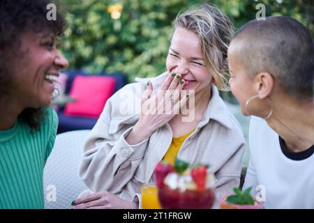 Three mature multiracial women laughing celebrating meeting outdoor. Best friends having fun. Stock Photo