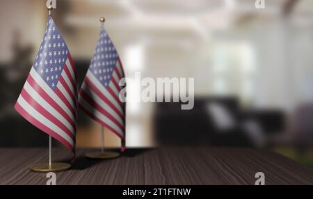 Small flags of the United States stand on the table. With meeting room background. close up. Blurred background. Stock Photo