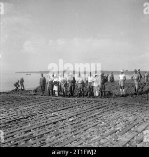 The Allied Reoccupation the Dutch East Indies On the shore near Denpasa on Bali, Japanese staff officers await the landing of the Dutch reoccupation force. These troops were men of the Royal Netherlands Indies Army Force (KNIL Force) and were ferried to Bali in British landing craft. Japanese Officers include Colonel Kobungo Tsuniska and Japanese Imperial Navy Captain Shizuo Okuyama. Stock Photo