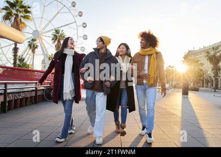 Group cheerful multi-ethnic friends enjoying winter vacations outdoor. Happy laughing young people. Stock Photo