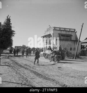 The British Army in Burma 1945 A Bren gun carrier and infantry enter Shwebo, the last important position in Burma before Mandalay, January 1945. Stock Photo