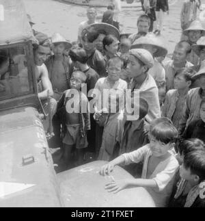 The British Reoccupation of Hong Kong Chinese villagers from Wew Territory crowd round the first British truck to reach their settlement. Stock Photo