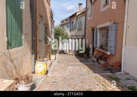 Narrow sloping street with colourful old houses in the ancient town of Arles in Provence, southern France. Stock Photo