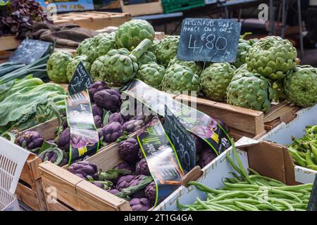 Artichokes displayed with prices for sale at the Saturday outdoor market in Arles, Provence, southern France. Stock Photo