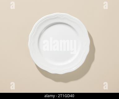 white empty plate on beige color background, top view Stock Photo
