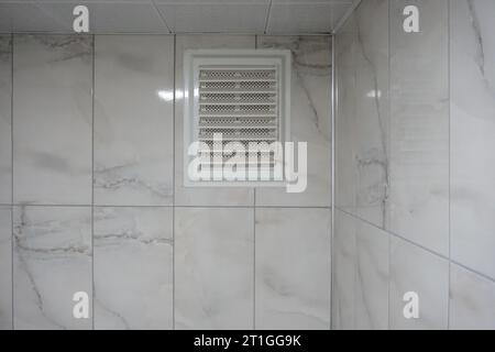 Toilet ventilation. air vent in the wall. Plastic air vent. Ventilation on marble wall. Stock Photo