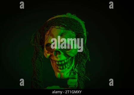 Close up view of green lighted skeleton head on black background. Halloween concept. Stock Photo