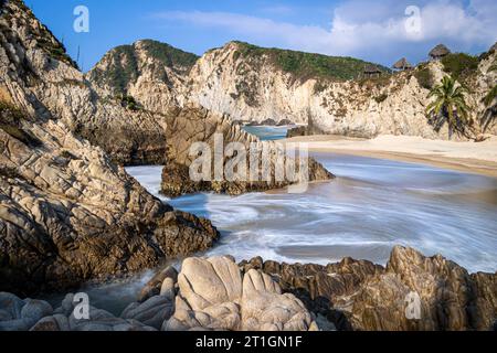 Rock formations protect the beach in Maruata, Michoacan, Mexico. Stock Photo