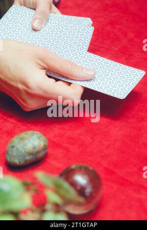 vertical image in profile view of female hand of unrecognizable caucasian woman placing tarot card on table from deck, to start reading and consultati Stock Photo