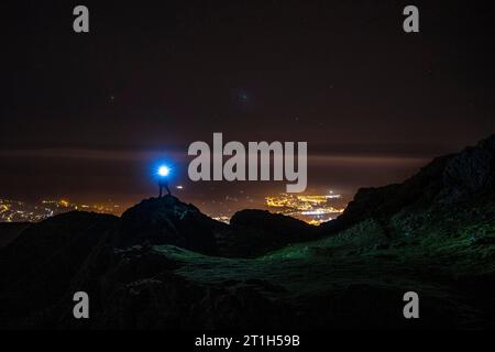Silhouette of a young man with a blue light on Mount Aiako Harria in Oiartzun. Basque Country Stock Photo
