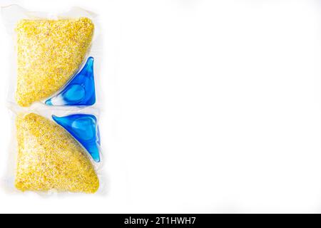 capsules with yellow powder and blue dishwasher gel place for inscription Stock Photo