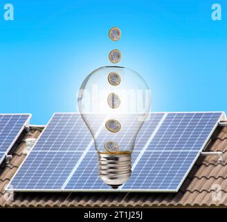 Money inside a light bulb with solar panel in the background Stock Photo