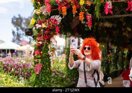 Canberra, Australia. 14th Oct, 2023. A woman takes selfies at the 'Windows to the World' event during the Floriade flower festival in Canberra, Australia, Oct. 14, 2023. Credit: Chu Chen/Xinhua/Alamy Live News Stock Photo