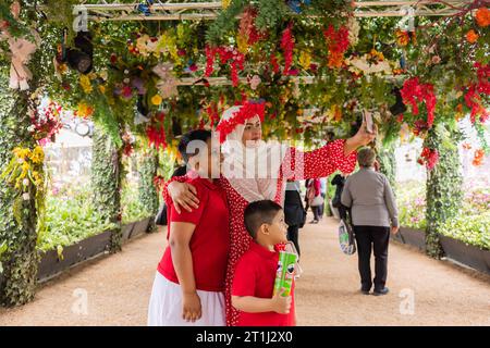 Canberra, Australia. 14th Oct, 2023. Visitors take selfies at the 'Windows to the World' event during the Floriade flower festival in Canberra, Australia, Oct. 14, 2023. Credit: Chu Chen/Xinhua/Alamy Live News Stock Photo