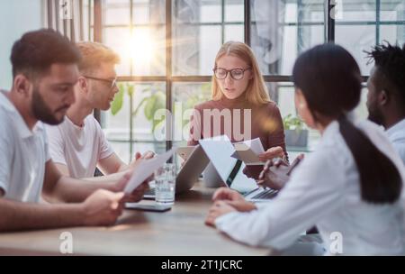 Team Working At Desks In Busy Office Stock Photo