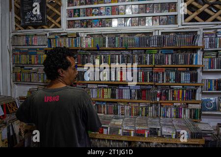 Bantul, Yogyakarta, Indonesia. 14th Oct, 2023. A shop owner prepares physical album recordings in cassette format at a music shop called Toko Musik Luwes in Bantul. According to data released by the Recording Industry Association of America (RIAA), music revenues are increasing, driven primarily by streaming services but also by sales of physical music formats. The report found that revenues from physical music formats have gradually increased over the years. Overall physical music revenue rose 4 percent last year, driven by a 17 percent increase in vinyl records. Physical releases of music Stock Photo
