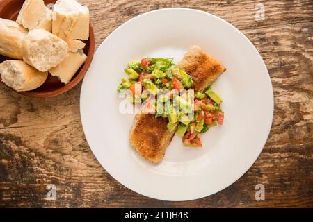 The cooked, fried fillet from a starry smooth hound, Mustelus asterias, caught in the English Channel, that has been served with an avocado and tomato Stock Photo