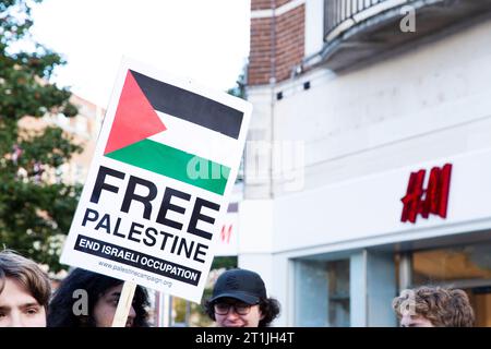 Free Palestine protest Exeter city centre - free Palestine sign next to H&M shop logo with tops of heads Stock Photo