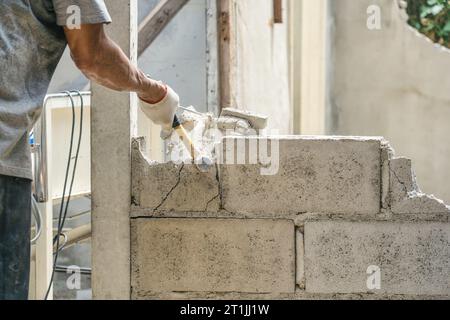 Hand of worker using hammer smashing and demolish on brick block wall at construction site Stock Photo