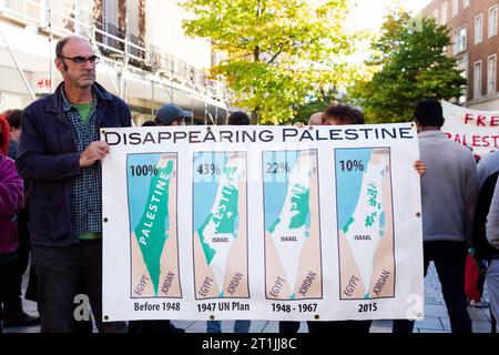 Free Palestine protest Exeter city centre - gentleman and hidden lady holding large 'disappearing Palestine' banner with map graphics and percentages Stock Photo