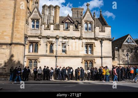Oxford, UK, 14th October 2023. Oxford University Freshers in white tie and gowns queue to punt on the River Cherwell at Magdalen Bridge boathouse after their Matriculation ceremony. Credit: Martin Anderson/Alamy Live News Stock Photo