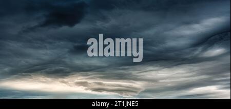 Panorama of dark dramatic sky with heavy cloud and storm formation in moody weather on overcast day Stock Photo