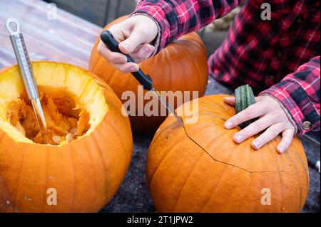 Opening the top of a pumpkin for carving halloween decorations with a knife Stock Photo