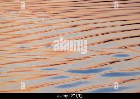Canada, Nunavut, Northwest Passage, Bellot Strait at sunrise. Water detail reflecting dawn colors. Stock Photo