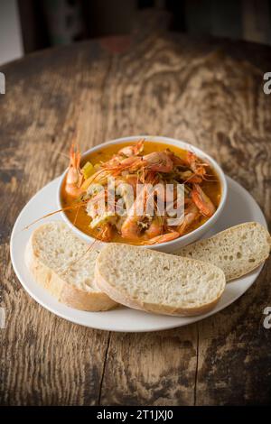 A fish soup, flavoured with saffron, containing Dover sole fillets, gurnard fillets and wild caught prawns. Dorset England UK GB Stock Photo