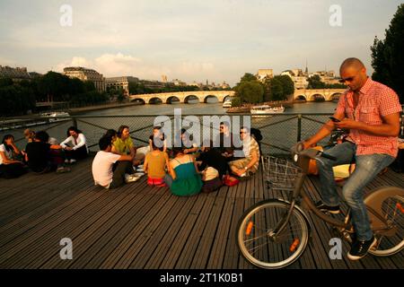 Party on the Pont des Arts, a foot bridge in Paris - Stock Photo