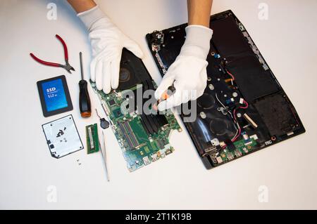 Top view. Technician repairing notebook computer, repairing motherboard and circuit. Stock Photo