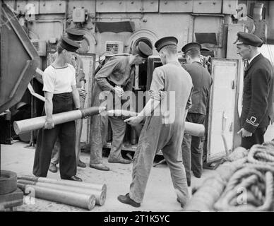 Life on Board Hm Corvette Widgeon, August 1943, in the North Sea and at Harwich, Men of the Corvette Widgeon Go About the Everyday Jobs of Their Wartime Routine. The First Lieutenant watching ammunition being taken in and stored in the ready use lockers. Stock Photo