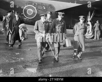 Royal Air Force Ferry Command, 1941-1943. The Prime Minister, Winston Churchill in RAF uniform, accompanied by Air Chief Marshal Sir Charles Portal, Chief of the Air Staff, leaving Consolidated Liberator 'Commando' of No. 24 Squadron RAF at Lyneham, Wiltshire, on their return from the Casablanca Conference. 24 Squadron provided VIP transport for the Prime Minister and Chiefs of Staff during the conference and their subsequent tour of the Middle East. Stock Photo