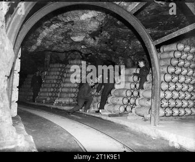 Royal Air Force Maintenance Command, 1939-1945. Storemen stack 250-lb MC bombs in one of the tunnels at No. 21 Maintenance Unit at Fauld, near Hanbury, Staffordshire. RAF Fauld, situated in a former gypsum mine, was the main repository of high explosive ordnance in the country. Part of the MU blew up on 27 November 1944, - the World's largest non-nuclear explosion, - and 70 servicemen and civilian workers were killed or declared missing. Stock Photo