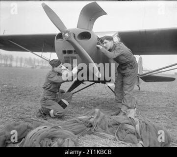 Royal Air Force- 2nd Tactical Air Force, 1943-1945. Two engine fitters, Aircraftman 1st class S Smith of Berkhamstead and Corporal G Drew of Dinton near Salisbury, give a daily inspection to a Taylorcraft-Auster Mark IV of 'B' Flight, No. 658 (AOP) Squadron RAF, in a field near Materborn, Kleve, Germany. Aircraft of the Squadron flew artillery spotting sorties in the area for 30 Corps of the British Army. Stock Photo